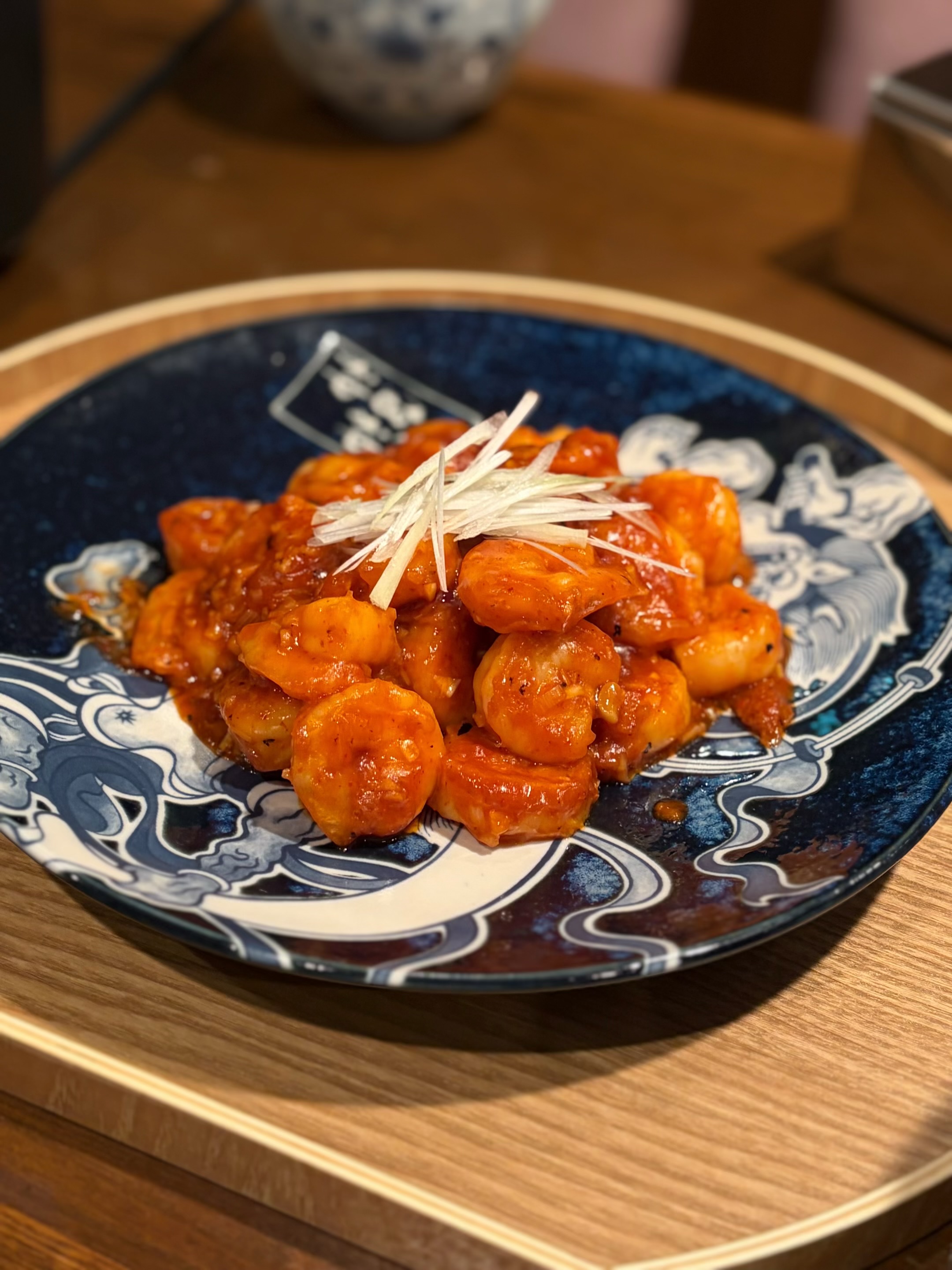 白髪ねぎを添えた赤いソースの料理